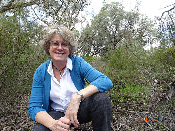 Jane crouching in bushland