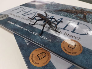 Toy insect resting on two books