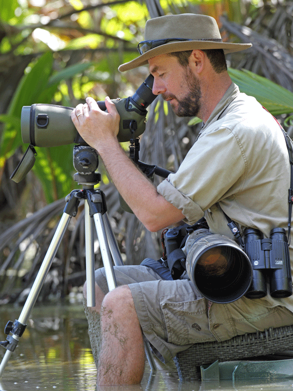 Rohan looking through viewfinder sitting in wetlands
