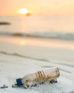 Photograph of a plastic bottle lying on the beach