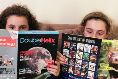 Two young girls reading Double Helix magazine