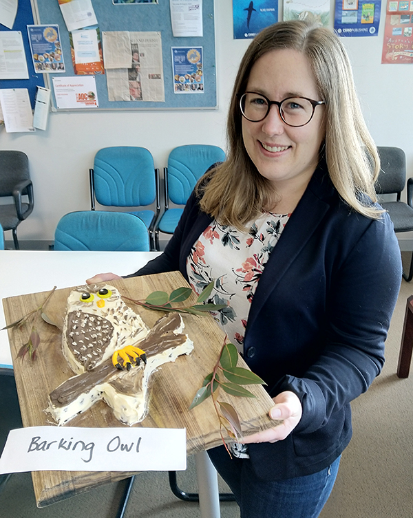 Woman holding a board with a Barking Owl cake