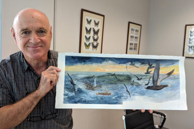 Man holding painting of birds over stormy sea