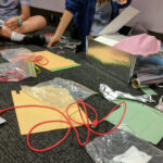 School children doing a coding activity the uses wires, alfoil and other craft supplies