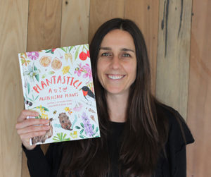 Photo of Cat Clowes holding copy of her book, Plantastic!