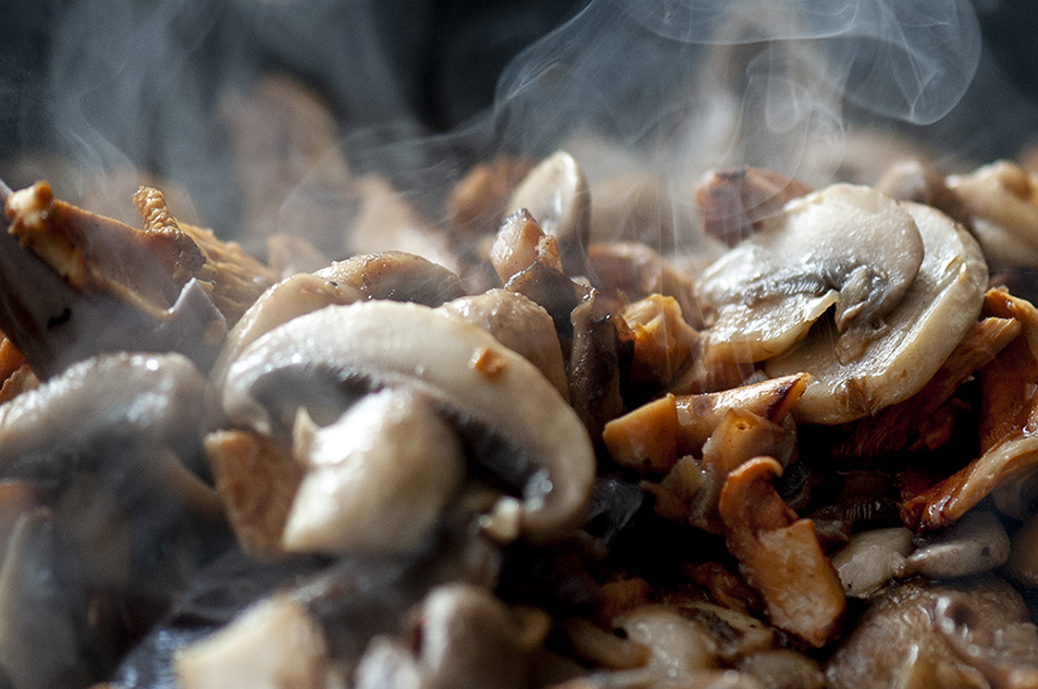 A close up photo of mixed mushrooms cooking