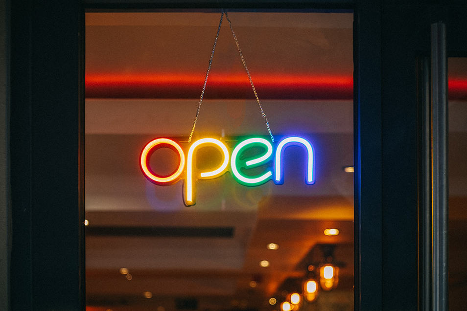 A multi-coloured neon "Open" sign hanging in a window.