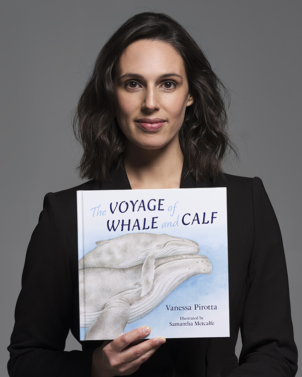 Vanessa Pirotta holding a copy of 'The Voyage of Whale and Calf'.