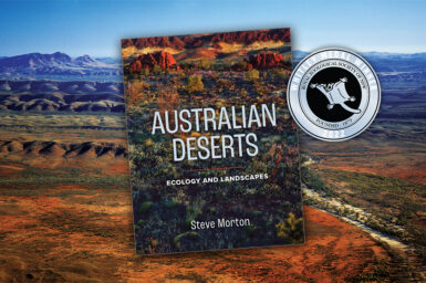The book Australian Deserts with the Whitley Medal Winner award sticker, upon a background image of a desert landscape.